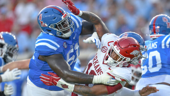 Arkansas Razorbacks linebacker Xavian Sorey takes a hard block from an Ole Miss Rebels offensive lineman