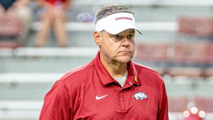 Arkansas Razorbacks offensive coordinator on the field in pregame warmups before game against the Tulsa Golden Hurricane at Razorback Stadium